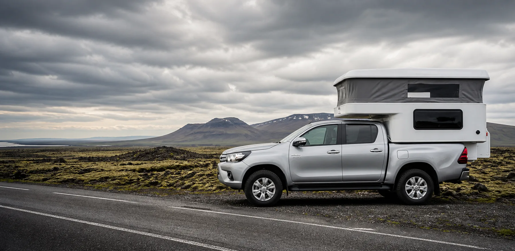 Silver Toyota Hilux four-wheel-drive camper beside an Icelandic road